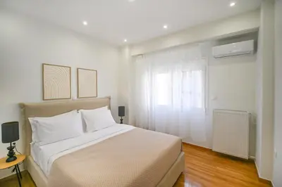 a white bedroom with a large bed and a window at LIV - Marvelous Apartment Near Acropolis in Athens