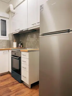 a stainless steel refrigerator in a kitchen with white cabinets at Bluebay Cozy Aparment 8 in Athens