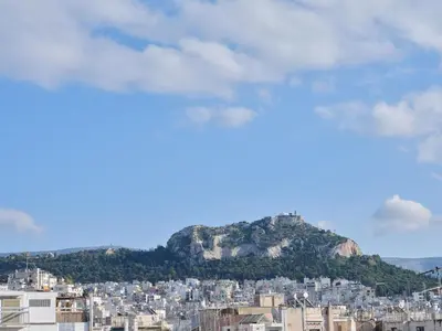 a view of a city with a mountain in the background at Stunning-Classical 1bd apartment in Athens