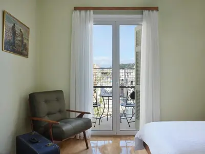 a bedroom with a bed and a chair and a balcony at Stunning-Classical 1bd apartment in Athens