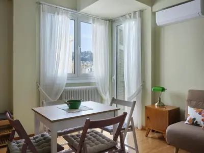 a dining room with a table and chairs and a window at Stunning-Classical 1bd apartment in Athens