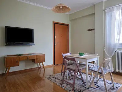 a living room with a table and chairs and a tv at Stunning-Classical 1bd apartment in Athens