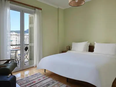 a bedroom with a large white bed and a balcony at Stunning-Classical 1bd apartment in Athens