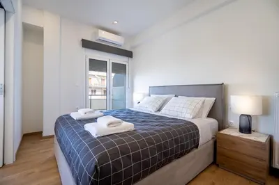 a bedroom with a bed with towels on it at Attiki Square & Metro Modern 2-Bedroom Apt by MPS in Athens