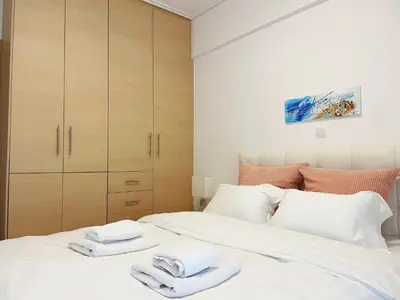 a bedroom with a white bed with towels on it at Bluebay comfort apartment 18 in Athens