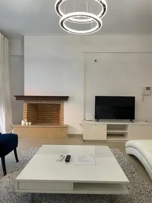 a living room with a table and a fireplace at Bluebay comfort apartment 18 in Athens
