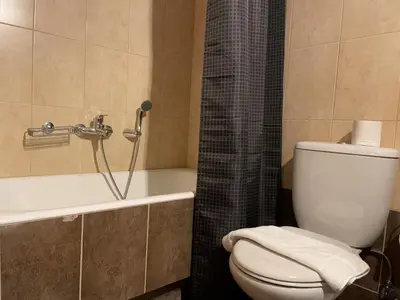 a bathroom with a white toilet and a bath tub at Bluebay comfort apartment 18 in Athens