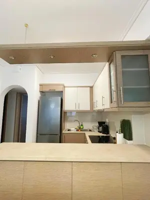 a kitchen with white cabinets and a stainless steel refrigerator at Bluebay comfort apartment 18 in Athens