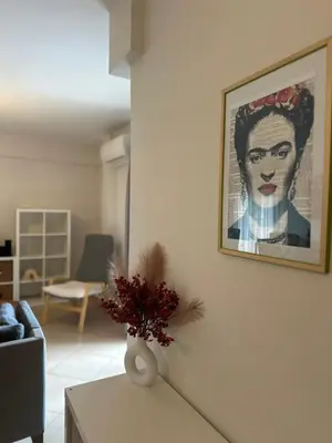 a living room with a painting of a woman on the wall at Koukaki - Athenian Glow in Athens