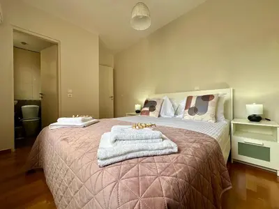 a bedroom with a large bed with two towels on it at Koukaki - Athenian Glow in Athens
