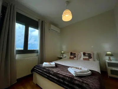 a bedroom with a bed and a large window at Koukaki - Athenian Glow in Athens