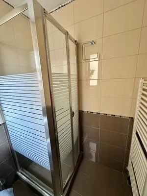 a shower with a glass door in a bathroom at Koukaki - Athenian Glow in Athens