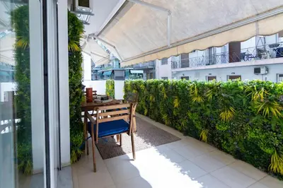 a balcony with a wooden table and a green hedge at Artistic 2bedroom Luxury Hop to Acropolis in Athens