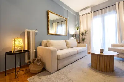 a living room with a white couch and a mirror at 65m2 Apt 10 min on Foot From Acropolis in Athens