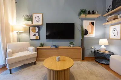 a living room with a tv and a couch and a table at 65m2 Apt 10 min on Foot From Acropolis in Athens