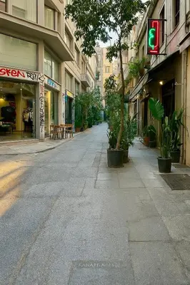 an empty street with a green traffic light and buildings at Queen Mary Psyri in Athens