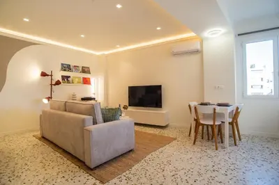 a living room with a couch and a table and a television at Queen Mary Psyri in Athens