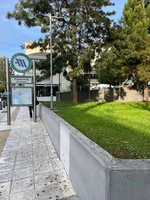 a street sign next to a field of grass at Chic & Cozy Apartment in Gazi, Athens in Athens