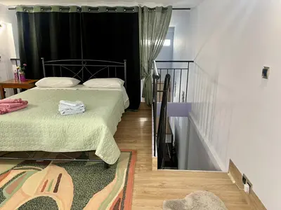 a bedroom with two beds with green sheets and a staircase at Chic & Cozy Apartment in Gazi, Athens in Athens