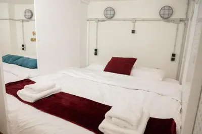 a white bed with white sheets and red pillows at 3Bed Loft 500m from Monastiraki Sq in Athens