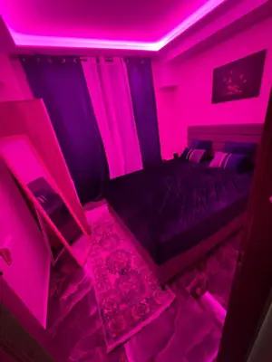 a room with a bed with a pink lighting at Kallithea Rent in Athens