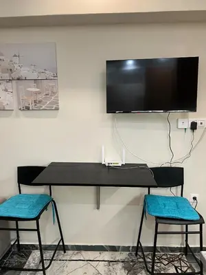 a black desk with two chairs and a tv on a wall at Kallithea Rent in Athens