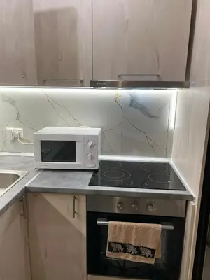 a kitchen with a stove and a microwave at Kallithea Rent in Athens