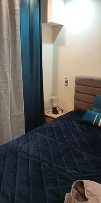 a bedroom with a blue bed and a blue curtain at Kallithea Rent in Athens