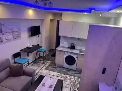 a living room with a couch and a kitchen with a microwave at Kallithea Rent in Athens