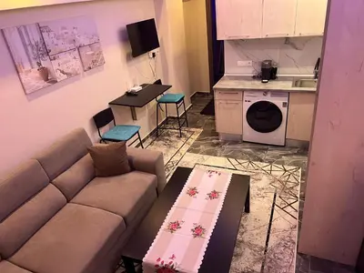 a living room with a couch and a kitchen at Kallithea Rent in Athens