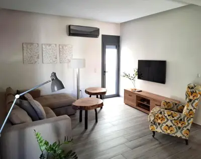 a living room with a couch and a tv at Cube House in Athens