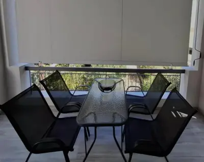 a glass table and chairs on a balcony at Cube House in Athens