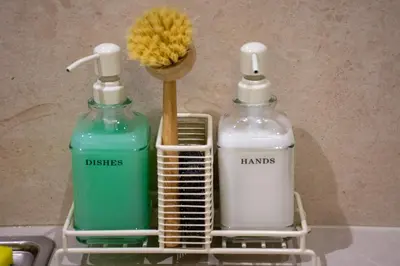 two bottles of detergent and a brush in a sink at Pixie Studio Athens in Athens