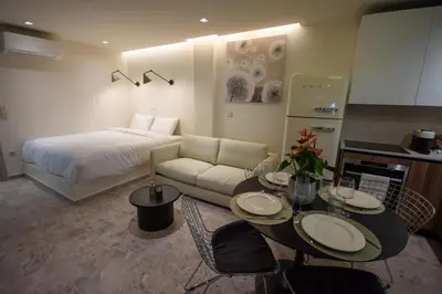 a room with a bed and a table and a couch at Pixie Studio Athens in Athens