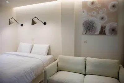 a bedroom with a bed and a couch and a painting at Pixie Studio Athens in Athens