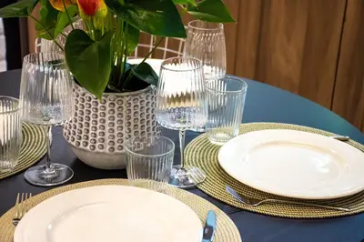 a table with plates and glasses and a vase with flowers at Pixie Studio Athens in Athens