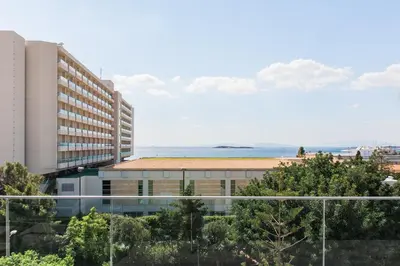 a view of a building with the ocean in the background at Raise Infinity Blue Penthouse in Athens