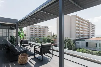 a patio with chairs and a table on a balcony at Raise Infinity Blue Penthouse in Athens
