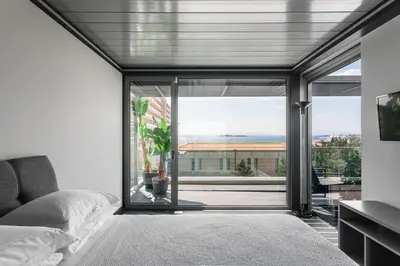 a bedroom with a bed and a large glass window at Raise Infinity Blue Penthouse in Athens
