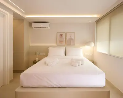 a bedroom with a large white bed with two towels at Margie Luxury suite in Athens