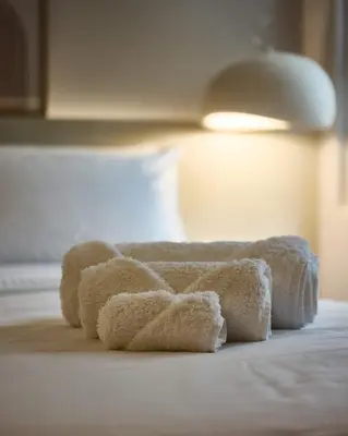 a group of towels sitting on top of a bed at Margie Luxury suite in Athens