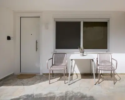 two chairs and a table in a room with a window at Margie Luxury suite in Athens
