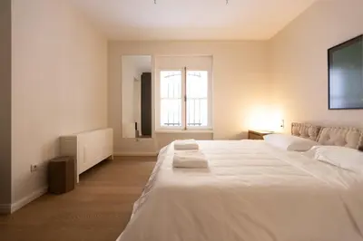 a white bedroom with a large white bed and a window at Theion Estate - A Blend of Art & Architecture in Athens Center by etouri in Athens