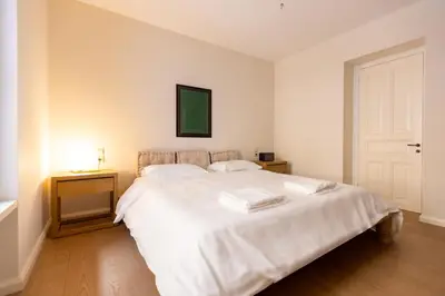 a bedroom with a large white bed and a door at Theion Estate - A Blend of Art & Architecture in Athens Center by etouri in Athens
