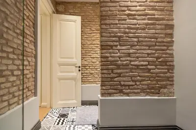 a hallway with a brick wall and a door at Theion Estate - A Blend of Art & Architecture in Athens Center by etouri in Athens