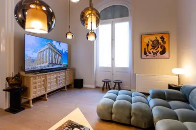 a living room with a couch and a television at Theion Estate - A Blend of Art & Architecture in Athens Center by etouri in Athens