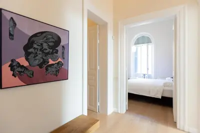 a white room with a bed and a painting on the wall at Theion Estate - A Blend of Art & Architecture in Athens Center by etouri in Athens