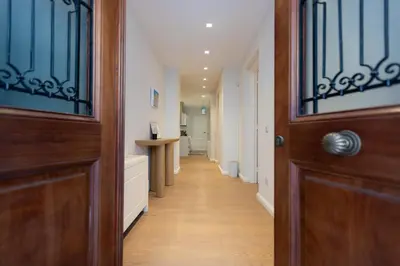 a hallway with a wooden door and a wooden floor at Theion Estate - A Blend of Art & Architecture in Athens Center by etouri in Athens