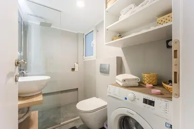 a bathroom with a washing machine and a sink at Cozy Pangrati Hideaway in Athens