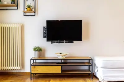 a living room with a tv on a wall at Cozy Pangrati Hideaway in Athens